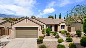 Ranch-style house with a garage, stucco siding, fence, a tile roof, and driveway