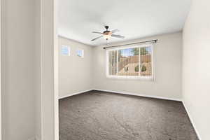 Carpeted spare room with baseboards and a ceiling fan