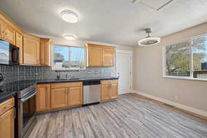 Sleek black counters with a metalic backsplash.  Brand new fixtures & floors.