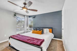 Carpeted bedroom featuring baseboards, a textured ceiling, and ceiling fan