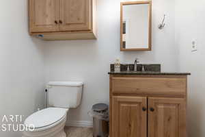 Bathroom featuring toilet, vanity, and baseboards