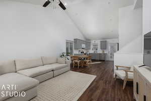 Living area featuring high vaulted ceiling, dark wood-type flooring, and ceiling fan