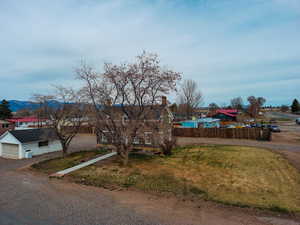 View of front of house with a residential view, a chimney, a mountain view, a garage, and fence