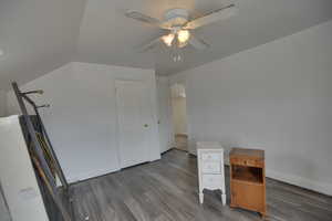 Unfurnished office with ceiling fan, baseboards, and wood finished floors