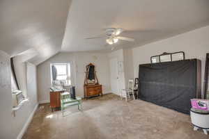 Bedroom featuring baseboards, vaulted ceiling, cooling unit, a ceiling fan, and carpet