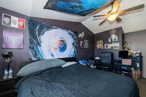 Carpeted bedroom featuring ceiling fan and lofted ceiling