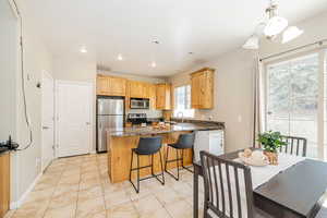 Kitchen featuring recessed lighting, dark stone counters, appliances with stainless steel finishes, a sink, and light brown cabinetry