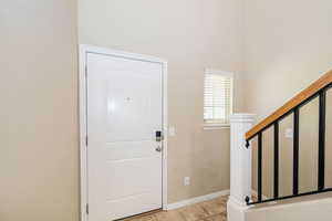 Entryway with light tile patterned floors and baseboards