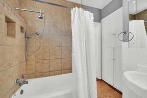 Bathroom featuring shower / bath combo with shower curtain and wood finished floors