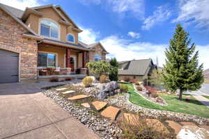 Craftsman-style house with covered porch, stucco siding, stone siding, and a garage