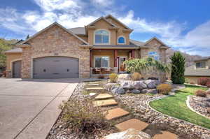 Craftsman house with concrete driveway, stucco siding, stone siding, a porch, and a garage