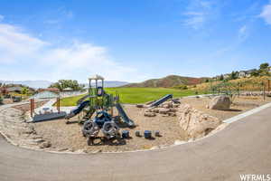 Community jungle gym with a gazebo, a mountain view, and a lawn
