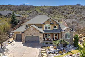 Craftsman-style home with stucco siding, a porch, stone siding, an attached garage, and concrete driveway