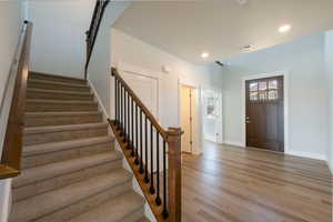 Foyer entrance featuring light wood-style floors, visible vents, recessed lighting, stairway, and baseboards