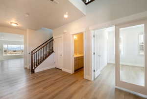 Interior space with visible vents, baseboards, recessed lighting, stairway, and light wood-style flooring