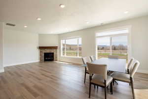Dining room with baseboards, recessed lighting, a textured ceiling, visible vents, and wood finished floors
