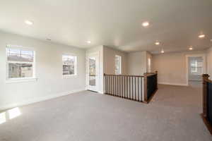 Carpeted empty room with recessed lighting and baseboards