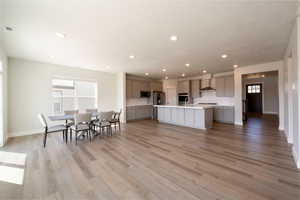 Kitchen with visible vents, wall chimney exhaust hood, light countertops, appliances with stainless steel finishes, and gray cabinetry