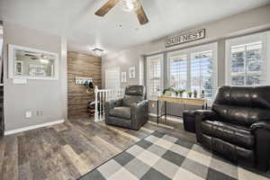 Sitting room featuring wood finished floors, ceiling fan, and baseboards