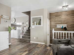 Interior space featuring a textured ceiling, wood finished floors, wooden walls, and baseboards