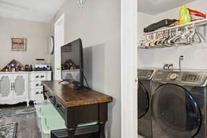 Clothes washing area featuring laundry area, washing machine and clothes dryer, and wood finished floors
