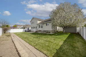 Rear view of property with a patio, a yard, and a fenced backyard