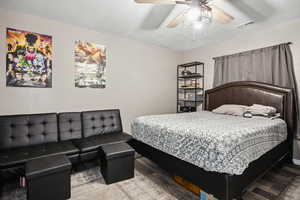 Bedroom with wood finished floors, a ceiling fan, and visible vents