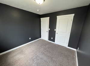 Empty room featuring visible vents, baseboards, a textured ceiling, and carpet floors