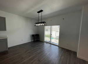 Unfurnished dining area featuring visible vents, baseboards, and dark wood finished floors