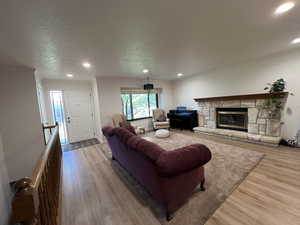 Living room featuring recessed lighting, wood finished floors, and a fireplace
