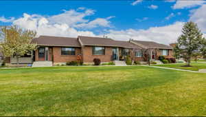 Ranch-style house featuring a front lawn and brick siding