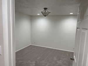 Empty room featuring baseboards, recessed lighting, carpet flooring, and a textured ceiling