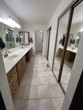 Master Bathroom with a sink, double vanity, and a textured ceiling