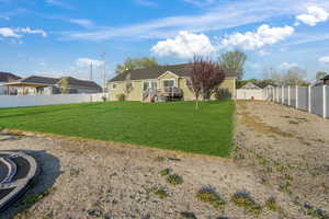 Rear view of house featuring a residential view, a fenced backyard, and a lawn