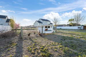 View of yard featuring fence, an outdoor structure, and exterior structure