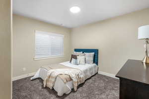 Carpeted bedroom with baseboards and visible vents