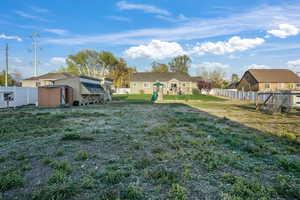 View of yard with a residential view, a shed, a fenced backyard, an outbuilding, and a playground