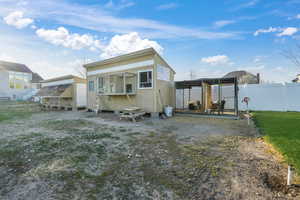 Back of house with an outdoor structure and fence