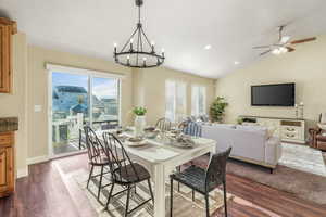 Dining room featuring plenty of natural light, vaulted ceiling, and dark wood-style floors