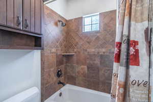 Full bath featuring toilet and shower / tub combo with curtain