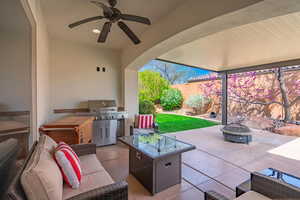 View of patio with an outdoor living space with a fire pit, grilling area, a ceiling fan, and fence