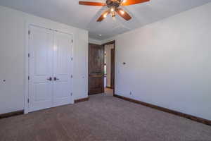 Unfurnished bedroom featuring a closet, a ceiling fan, visible vents, carpet flooring, and baseboards