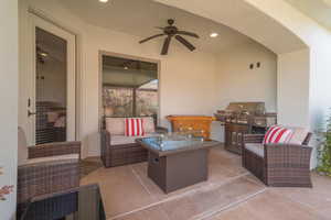 View of patio with grilling area, an outdoor living space, and a ceiling fan