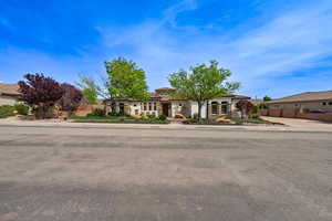 View of front of property with a tile roof, fence, and stucco siding