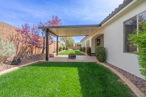 View of yard with a patio area, a fenced backyard, and a fire pit