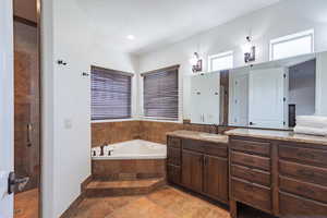 Full bath with vanity, a stall shower, and a garden tub