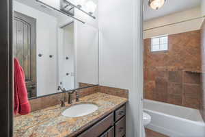 Bathroom featuring visible vents, toilet, vanity, and tub / shower combination