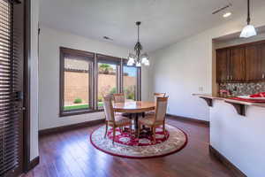 Dining space featuring a notable chandelier, visible vents, and baseboards