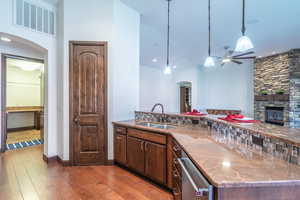 Kitchen with ceiling fan, arched walkways, visible vents, a sink, and light wood finished floors