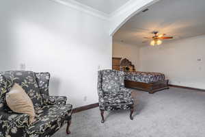 Carpeted bedroom featuring arched walkways, baseboards, ornamental molding, and visible vents